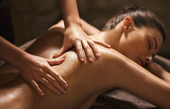 Photo d'une jeune femme profitant d'un modelage relaxant aux huiles chaudes.